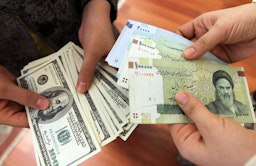 ایرانیان در حال مبادله‌ی اسکناس‌های ۱۰۰ دلاری آمریکا با ریال ایران؛ تهران، ایران، ۲۲ دی ۱۳۹۰. (عکس از گتی ایمیجز)