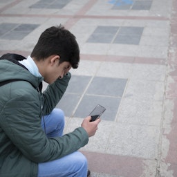 مرد جوان ایرانی در حال بررسی شبکه‌های اجتماعی در گوشی هوشمند خود؛ تهران، ایران، ۴ اسفند ۱۴۰۰. (عکس از گتی ایمیجز)