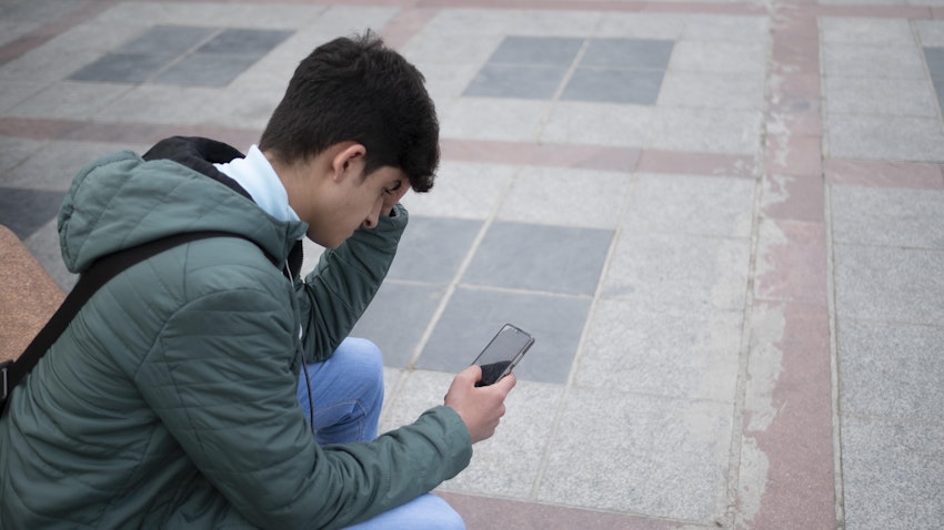 مرد جوان ایرانی در حال بررسی شبکه‌های اجتماعی در گوشی هوشمند خود؛ تهران، ایران، ۴ اسفند ۱۴۰۰. (عکس از گتی ایمیجز)