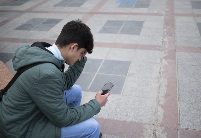 شاب إيراني يستخدم هاتفه الذكي لتفقد حسابه على وسائل التواصل الاجتماعي في طهران، إيران، في 23 فبراير/شباط 2022. (الصورة عبر غيتي إيماجز)