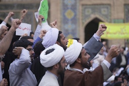 طلاب جامعيون ورجال دين يتظاهرون أمام مدرسة فايزية في قم بإيران، 30 مايو/ أيار 2015. (الصورة عبر غيتي إيماجز)