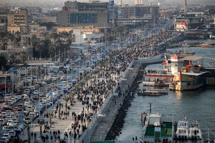 People walk past the pier along the waterfront of the Shatt al-Arab waterway in Basra, Iraq on Jan. 18, 2023. (Photo via Getty Images)