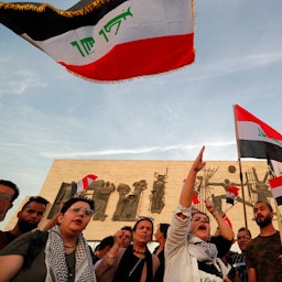 اهتزاز پرچم‌های عراق توسط تظاهرکنندگان؛ میدان تحریر، بغداد، عراق، ۳ آبان ۱۴۰۱/ ۲۵ اکتبر ۲۰۲۲. (عکس از گتی ایمیجز)