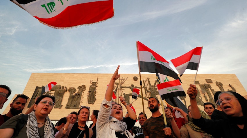 متظاهرون يلوحون بالأعلام العراقية في ساحة التحرير ببغداد، العراق، يوم 25 أكتوبر/تشرين الأول 2022. (الصورة عبر غيتي إيماجز)