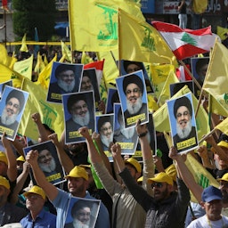 Supportes of the Lebanese Shiite movement Hezbollah raise images of the group's leader Hassan Nasrallah in Nabatiyeh, Lebanon on May 9, 2022. (Photo via Getty Images)
