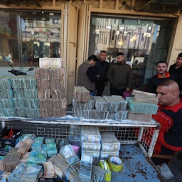 المواطنون يشترون ويبدلون العملات الأجنبية في مكتب صرافة في بغداد، العراق. 25 يناير/كانون الثاني 2023. (الصورة عبر غيتي إيماجز)