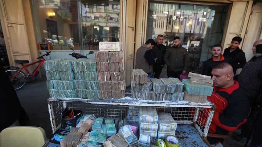 المواطنون يشترون ويبدلون العملات الأجنبية في مكتب صرافة في بغداد، العراق. 25 يناير/كانون الثاني 2023. (الصورة عبر غيتي إيماجز)