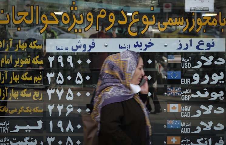 An Iranian woman walks by a currency exchange shop in Tehran’s business district on Oct. 10, 2020. (Photo via Getty Images)
