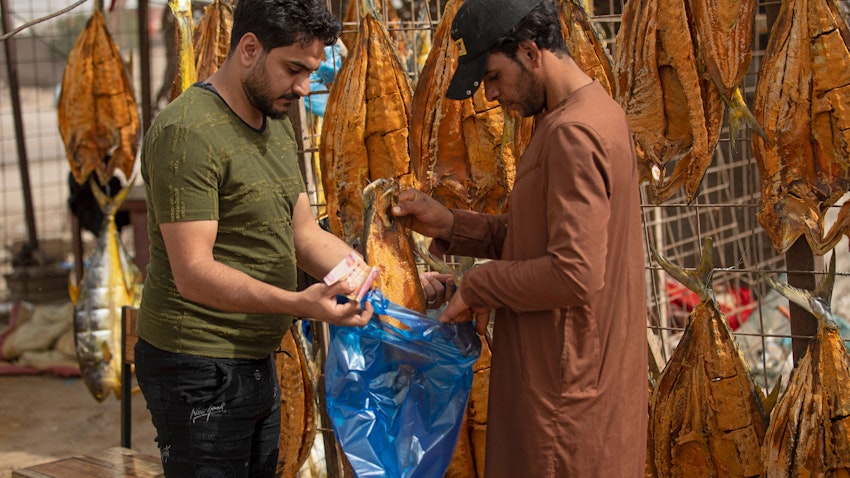 بائع يبيع أسماكًا مجففة في مدينة البصرة بجنوب العراق. 29 أبريل/نيسان 2022. (الصورة عبر غيتي إيماجز)