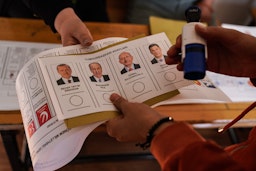 An election official displays a voting card with the faces of candidates in Kahramanmaras, Turkey on May 14, 2023. (Photo via Getty Images)