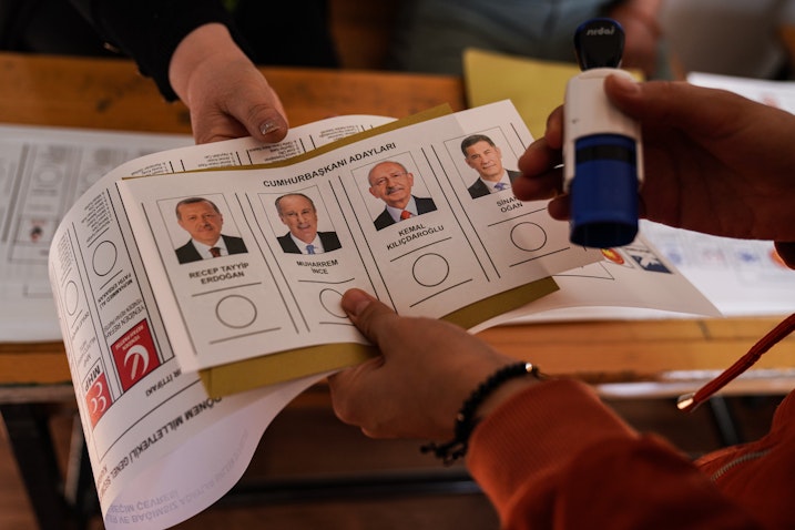 An election official displays a voting card with the faces of candidates in Kahramanmaras, Turkey on May 14, 2023. (Photo via Getty Images)