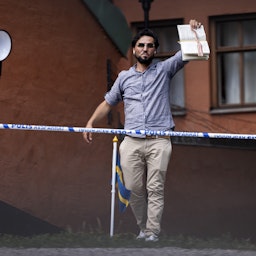 A man burns a copy of the Quran and covers it with bacon in Stockholm, Sweden on June 28, 2023. (Photo via Getty Images)