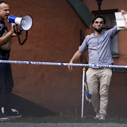 رجل يحرق نسخة من القرآن ويغطيها بلحم مقدد في ستوكهولم بالسويد. 28 يونيو/حزيران 2023. (الصورة عبر غيتي إيماجز)