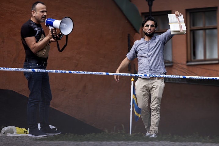 رجل يحرق نسخة من القرآن ويغطيها بلحم مقدد في ستوكهولم بالسويد. 28 يونيو/حزيران 2023. (الصورة عبر غيتي إيماجز)