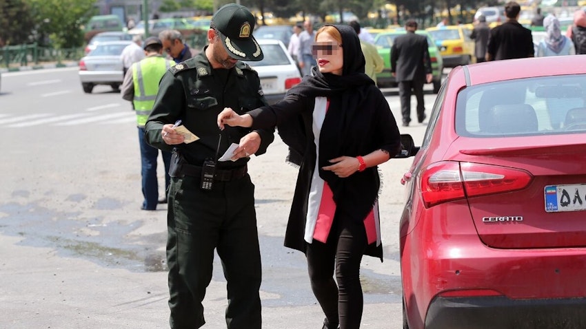 A woman is stopped and fined by the morality police for not having the proper Islamic dress code in Tehran, Iran on Apr. 16, 2016. (Photo via IRNA)