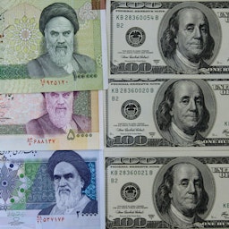 تصویری از انواع اسکناس ایرانی در کنار اسکناس‌های ۱۰۰ دلاری آمریکا؛ تهران، ایران، ۲۸ دی ۱۳۹۰. (عکس از گتی ایمیجز)
