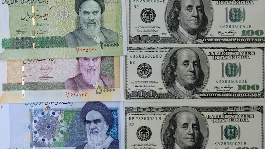 Photo of various Iranian banknotes next to United States 100-dollar bills. Picture taken in Tehran, Iran on Jan. 18, 2012. (Photo via Getty Images)