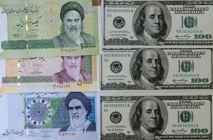 Photo of various Iranian banknotes next to United States 100-dollar bills. Picture taken in Tehran, Iran on Jan. 18, 2012. (Photo via Getty Images)