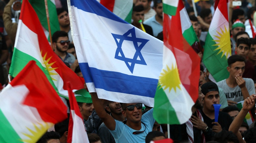 Iraqi Kurds wave Israeli and Kurdish flags during an event in Erbil, northern Iraq, on Sept. 16, 2017. (Photo via Getty Images)