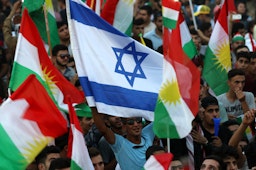 Iraqi Kurds wave Israeli and Kurdish flags during an event in Erbil, northern Iraq, on Sept. 16, 2017. (Photo via Getty Images)