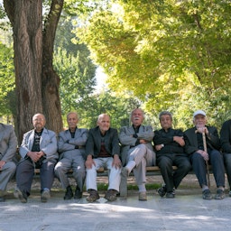 پیرمردان ایرانی نشسته بر روی نیمکتی در چهل ستون؛ اصفهان، ایران، ۲۲ مهر ۱۳۹۵. (عکس از گتی ایمیجز)