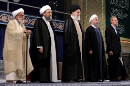 علی خامنه‌ای، ولی فقیه و رهبر ایران؛ حسن روحانی، رئیس‌جمهور سابق، و سایر مقامات عالی‌رتبه در مراسمی در تهران؛ ایران، ۱۲ مرداد ۱۳۹۶. (عکس از وب‌سایت رهبر ایران)