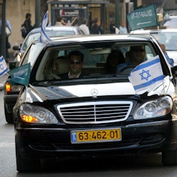 سيارة من نوع ليموزين تحمل أعلام المملكة العربية السعودية وإسرائيل تشق طريقها عبر شوارع تل أبيب في 10 أبريل/ نيسان 2007. (الصورة عبر غيتي إيماجز)