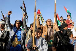 Yemen’s Houthi fighters raise their weapons during a protest following US and UK strikes, Sana’a, Jan. 12, 2024. (Photo via Getty Images)