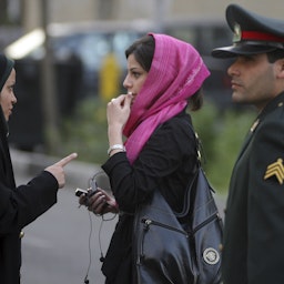 اخطار پلیس امنیت اخلاقی به یک بانوی ایرانی در مورد پوشش و موهایش، برای اعمال قانون پوشش اسلامی؛ تهران، ایران، ۲ اردیبهشت ۱۳۸۶. (عکس از گتی ایمیجز)