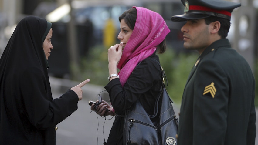 اخطار پلیس امنیت اخلاقی به یک بانوی ایرانی در مورد پوشش و موهایش، برای اعمال قانون پوشش اسلامی؛ تهران، ایران، ۲ اردیبهشت ۱۳۸۶. (عکس از گتی ایمیجز)