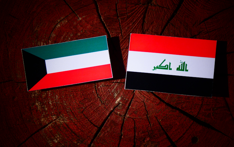 پرچم‌های عراق و کویت، بر یک کنده‌ی درخت. (عکس از گتی ایمیجز)
