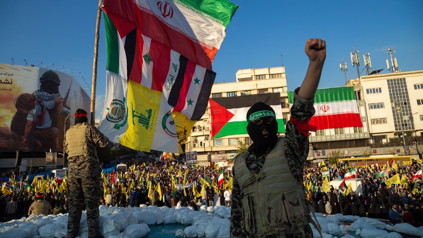 Unidentified men wearing masks and military uniforms wave the flags of Iran, Palestine, Lebanon, Iraq, Syria, Hezbollah, Fatemiyoun Brigade, and PMU at a pro-Palestine rally in Tehran, Iran on Nov. 18, 2023. (Photo via Getty Images) Unidentified men wearing masks and military uniforms wave the flags of Iran, Palestine, Lebanon, Iraq, Syria, Hezbollah, Fatemiyoun Brigade, and PMU at a pro-Palestine rally in Tehran, Iran on Nov. 18, 2023. (Photo via Getty Images)