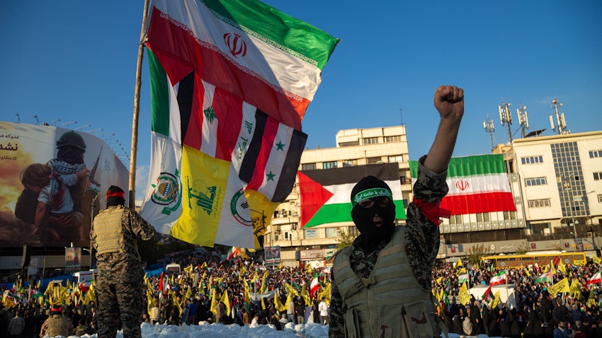 رجال مجهولون يرتدون أقنعة وبدلات عسكرية يلوحون بأعلام إيران وفلسطين ولبنان والعراق وسوريا وحزب الله ولواء فاطميون وقوات الحشد الشعبي في تجمع مؤيد لفلسطين في طهران، إيران. 18 نوفمبر/تشرين الثاني 2023. (الصورة عبر غيتي إيماجز) رجال مجهولون يرتدون أقنعة وبدلات عسكرية يلوحون بأعلام إيران وفلسطين ولبنان والعراق وسوريا وحزب الله ولواء فاطميون وقوات الحشد الشعبي في تجمع مؤيد لفلسطين في طهران، إيران. 18 نوفمبر/تشرين الثاني 2023. (الصورة عبر غيتي إيماجز)