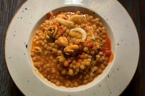 Piatto di fregula sarda con pesce
