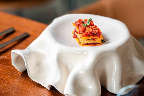 Cold lasagnetta with lamb tartare, pasta sheets, a crispy fried wafer and crunchy topping, created by chef Andrea Pani.