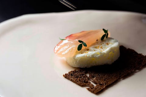 "Incontro", a dish by chef Andrea Pani of Casa Marmida, featuring raw dentex with mastic and rue, solid mozzarella foam and a crisp black bread wafer.