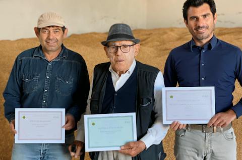 Tre uomini posano con attestati in mano, a testimonianza di un percorso professionale legato al settore agricolo.
