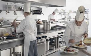 Industrial kitchen with people preparing meals in a restaurant