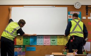 Trabajadores de mantenimiento ayudando en un salón de clases