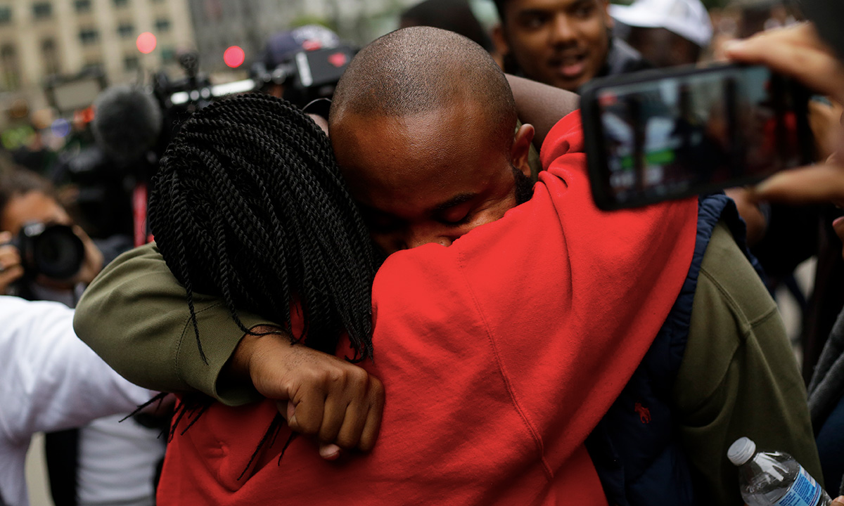 Activist William Calloway receives a hug from a protester