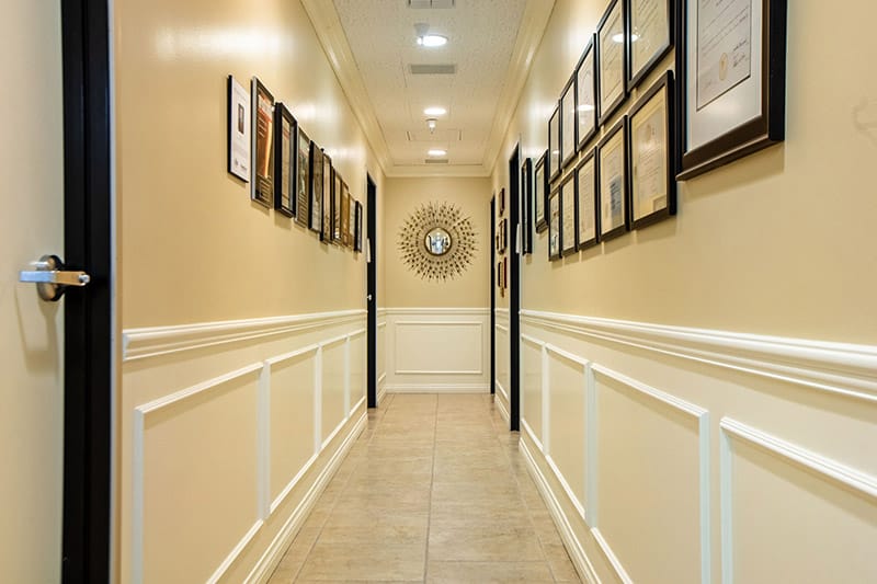 photo of one of the hallways inside of Wirth Plastic Surgery, with picture frames on the wall.