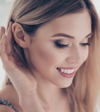 beautiful woman bringing hair back to reveal right ear