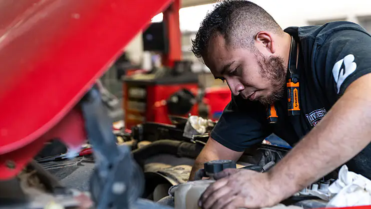 Auto Repair technician working on car engine