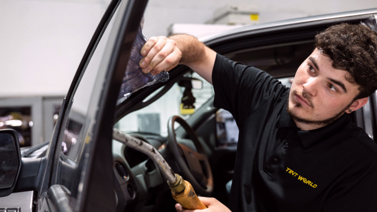 technician removing window tinting