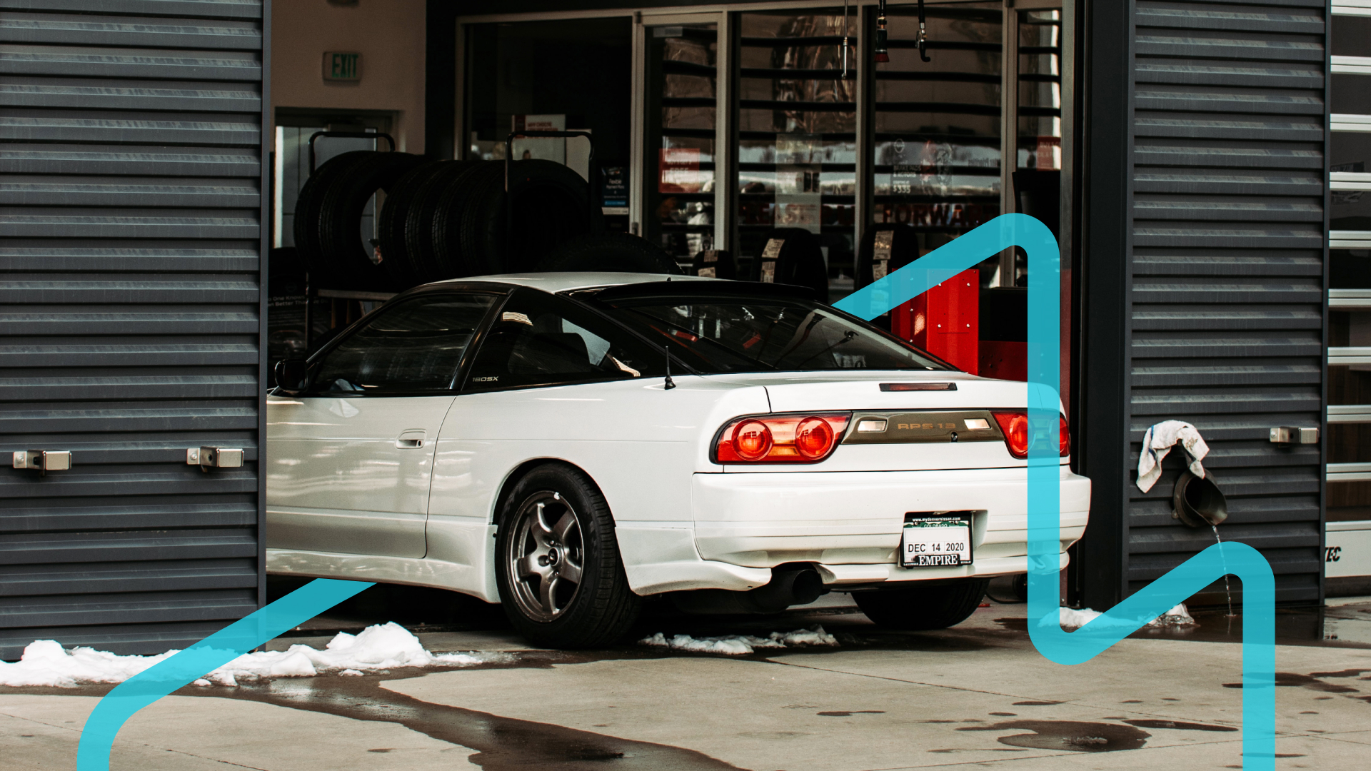 A white RPS 13 entering a shop in the winter with a blue graphic placed around it.