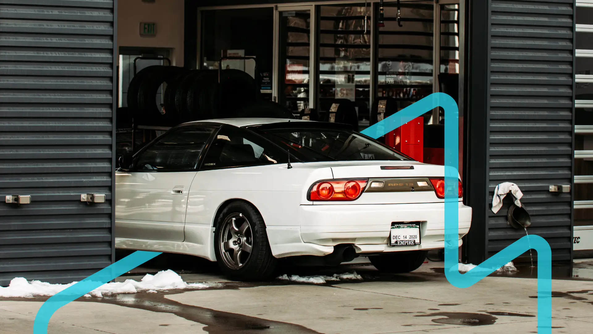 A white RPS 13 entering a shop in the winter with a blue graphic placed around it.