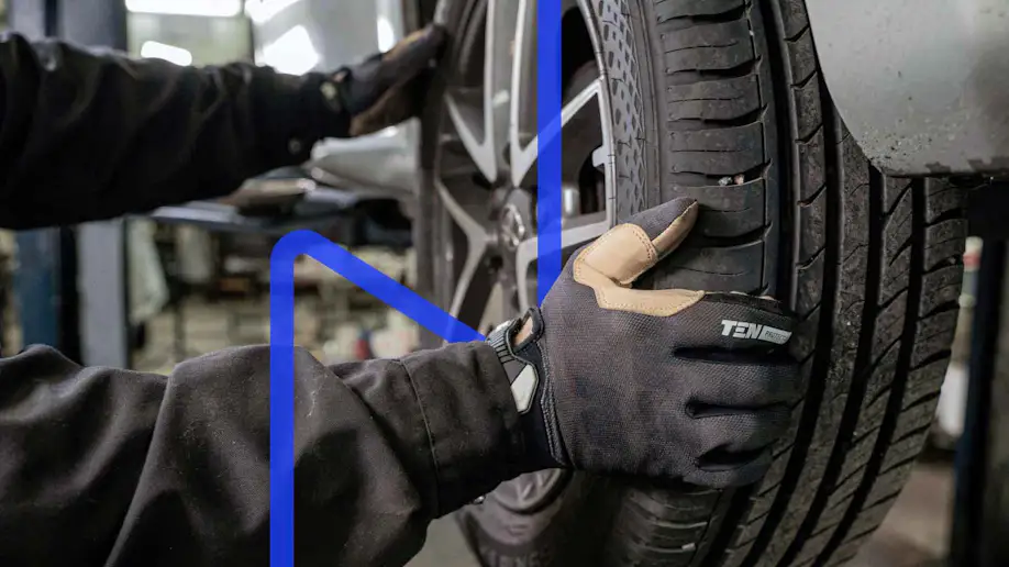 Gloved hands changing a tire.
