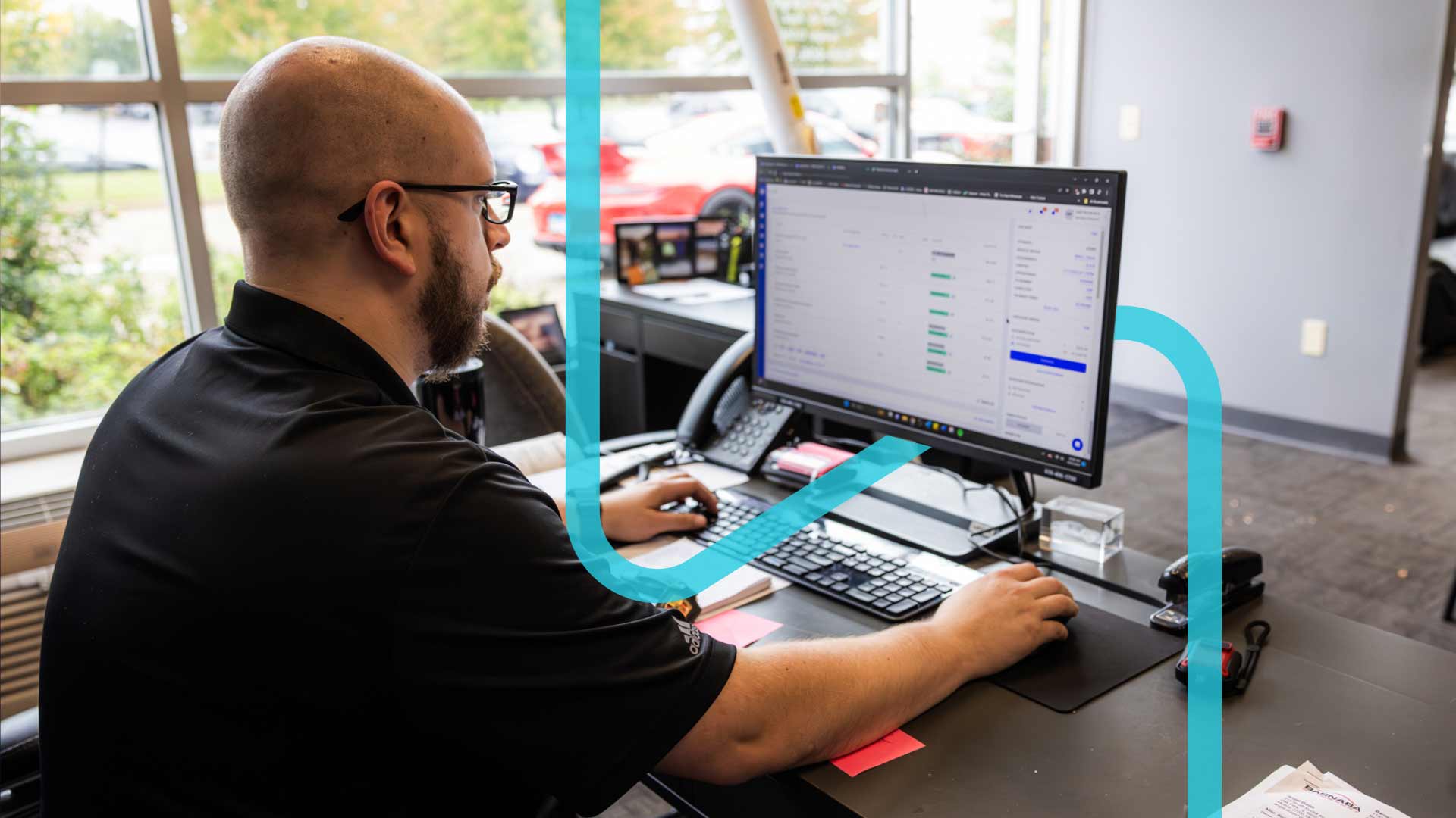 Man with a beard and glasses using Shopmonkey on a desktop.