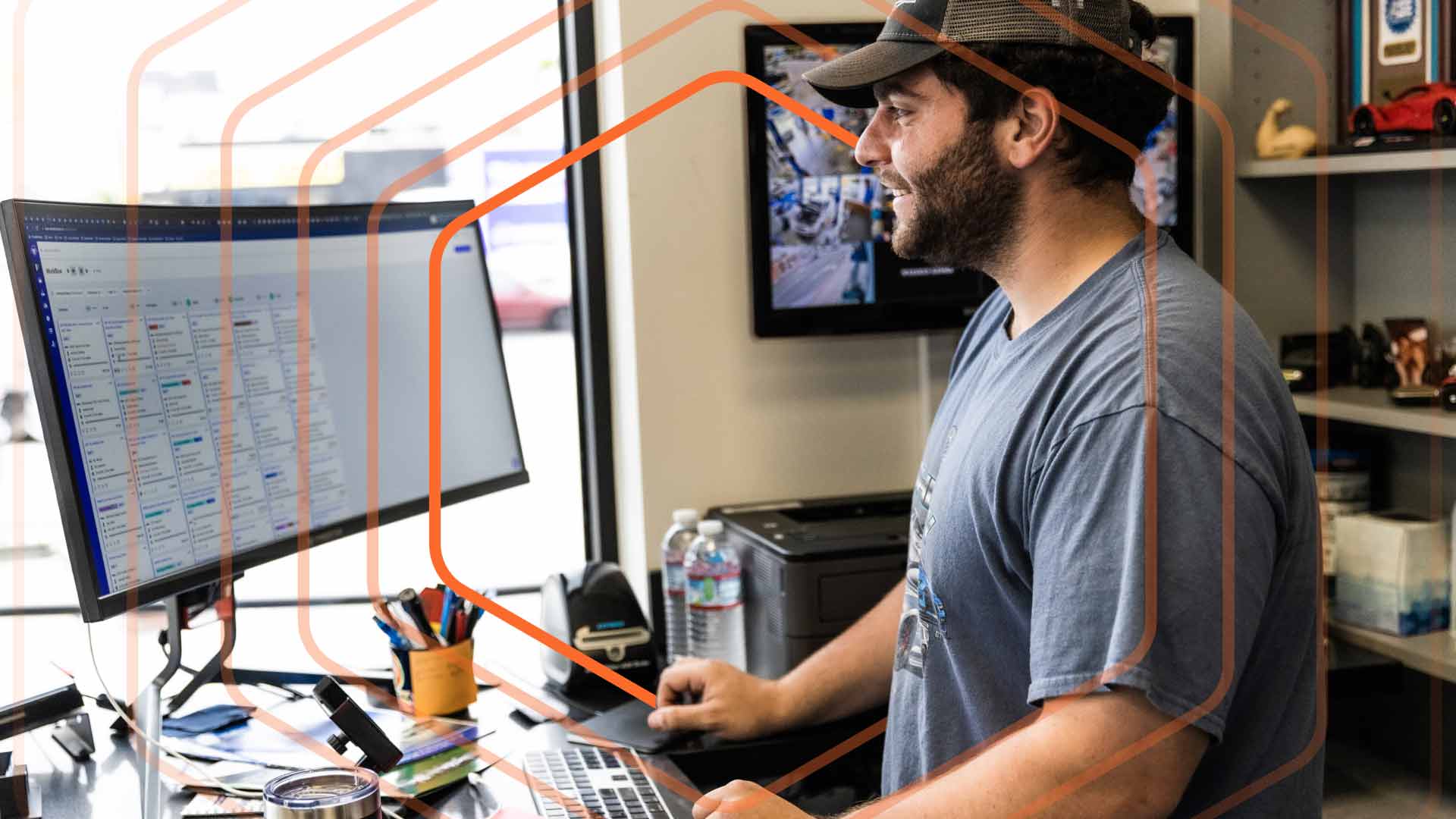 Man with hat and beard working on a desktop with Shopmonkey.