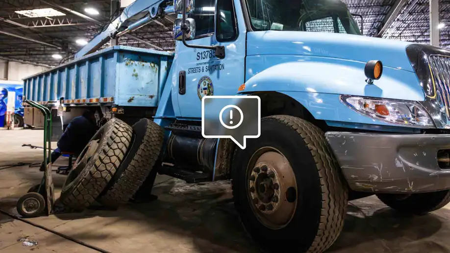 A heavy duty truck with a warning symbol on its tire.